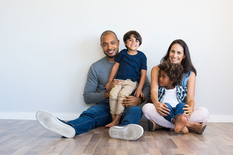 A family of four sitting together and smiling